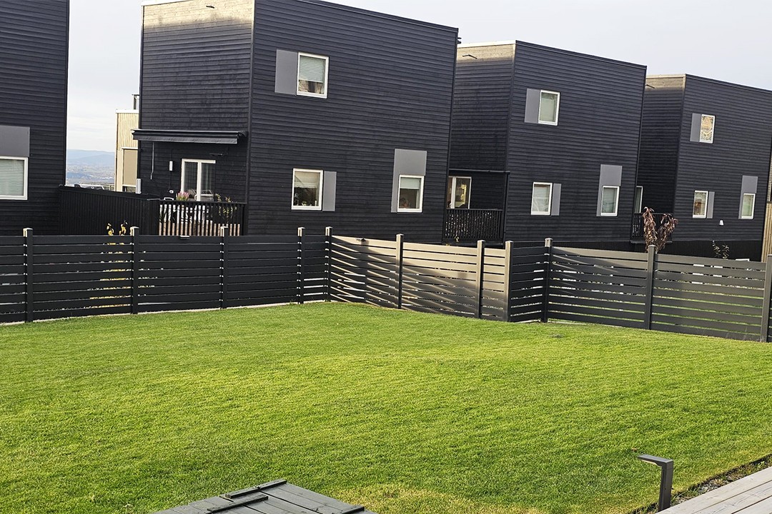 SHENGJIE slat fencing used around an outdoor lawn and residential buildings