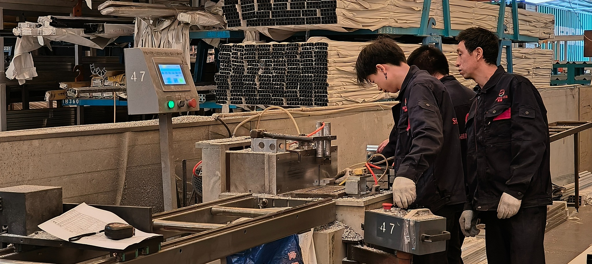 SHENGJIE workers handling aluminum profiles at a production workstation